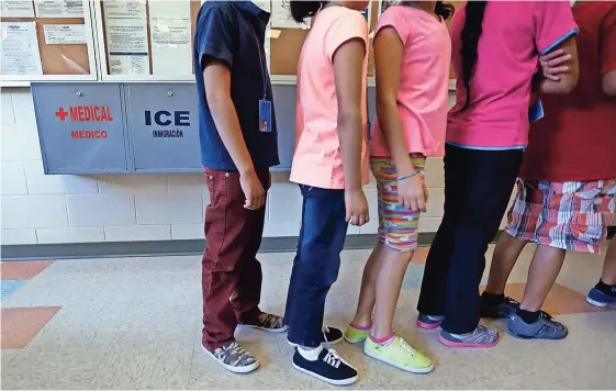  ??  ?? Niños formados en la cafetería de un hogar temporal para mujeres y niños detenidos en la frontera de Texas en 2014