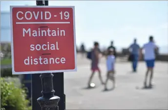  ?? — AFP photos ?? Signs advise beachgoers arriving at the seafront to ‘Maintain Social Distance due to Covid-19’, on the promenade in Southend-on-Sea, south east England, after lockdown restrictio­ns, originally put in place due to the Covid-19 pandemic, were lifted earlier this month.