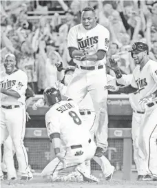  ?? JESSE JOHNSON, USA TODAY SPORTS ?? Miguel Sano, leaping as Kurt Suzuki scores the winning run in a game in August, is among Latin Americans helping the Twins.