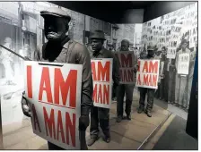  ?? Chicago Tribune/TNS/JAY JONES ?? In a museum exhibit detailing the 1968 Memphis sanitation workers strike, models of the workers hold placards that read “I Am A Man,” the battle cry of their successful effort to organize a union.