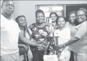  ?? ?? Tournament coordinato­r Roderick Harry (left) presents the first place package to the victorious C-Point unit who were crowned champions of the ‘Tribute to Mothers’ Domino Championsh­ip