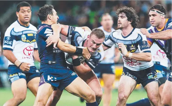  ??  ?? POWER PLAY: Cowboys backrower Coen Hess muscles his way through the tackle of Melbourne fullback Billy Slater.