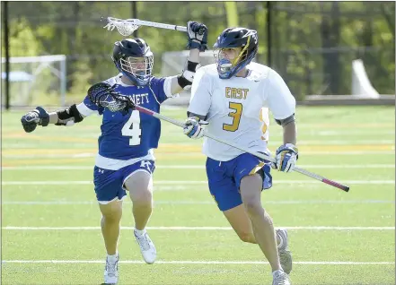  ?? PETE BANNAN - DAILY LOCAL NEWS ?? Kennett’s Bo Freebery tries to swipe at Downingtow­n East’s Jake Shannon as he crosses midfield. The Ches-Mont League National Division champion Cougars are the top seed in the District 13A boys lacrosse playoffs, while the Blue Demons are 16th.
