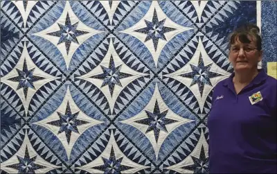  ??  ?? Jacki Alsip, historian for Desert Quilters of Imperial Valley, stands with her “Blue Beauty” quilt at this weekend’s quilt show at Southwest High School. Alsip estimates she has about 500 hours of work in the project. PHOTO TOM BODUS