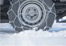  ?? FOTO: DPA ?? Das Aufziehen von Schneekett­en sollten Autofahrer vor dem Urlaub bereits einmal geübt haben.