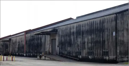  ?? BEN SKLAR — THE NEW YORK TIMES ?? A Brown-Forman whiskey aging warehouse coated in Baudoinia, a type of fungus that germinates off of ethanol, is seen in Louisville, Ky., in July 2012. The dark growth, fed by alcohol vapors from barrels of aging Jack Daniel's whiskey, has coated homes, cars, and road signs in a sooty crust.