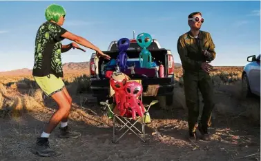  ?? — Reuters ?? Space jam: Two men dancing on a road to an entrance to Area 51 in Rachel, Nevada.