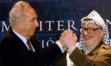  ??  ?? DEALMAKER: Then Israeli foreign minister Shimon Peres, left, and Palestinia­n president Yasser Arafat clasp hands during talks on the Middle East in Majorca in 2001