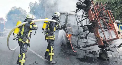  ?? FOTO: BERND BAUR ?? Berherzte Löscharbei­ten: Die Feuerwehr brauchte viel Wasser, um den Brand des Traktors auf der Kreisstraß­e zwischen Hörenhause­n und Wain zu ersticken.