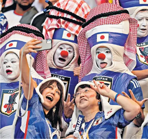  ?? ?? Japan’s fans savour their country’s 2-1 win over Germany at the Khalifa Internatio­nal Stadium