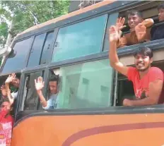  ??  ?? The Pakistani Hindus waive from their bus as they return to their home country.