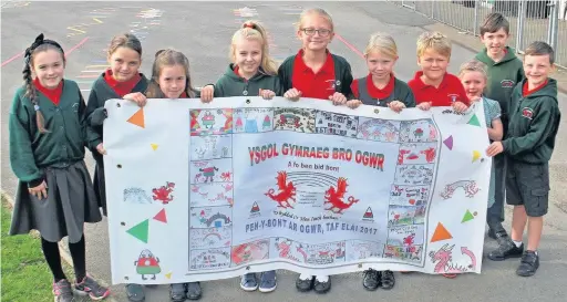  ??  ?? Pupils from Ysgol Gymraeg Bro Ogwr with a fantastic banner that they have made for Saturday’s Urdd parade through Bridgend town centre