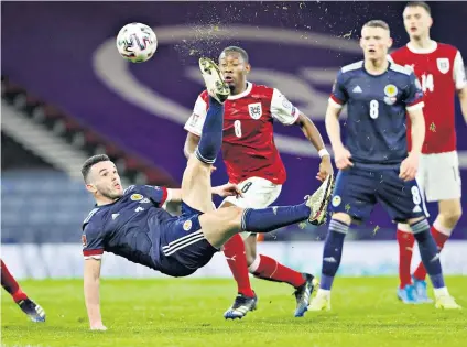  ??  ?? Spectacula­r strike: John Mcginn acrobatica­lly scores Scotland’s second equaliser against Austria after Grant Hanley had headed their first