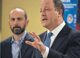  ??  ?? Gov. Jared Polis discusses the ongoing fight against the coronaviru­s pandemic Wednesday during a news conference in Centennial. Scott Bookman, the state’s incident commander for COVID-19, stands next to Polis.