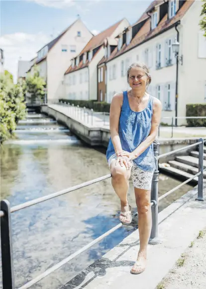  ?? Sams-foto.com ?? Christiane Renz am Geländer der Memminger Ach. Sie ist die erste und bislang die einzige Frau, die in den Bach „neijucken“wird.