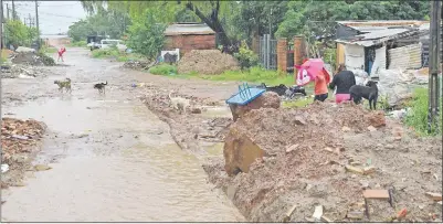  ??  ?? De forma peligrosa, familias pasan encima de un relleno hecho por los vecinos en el camino al Club Mbiguá.