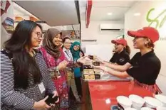  ??  ?? KAKITANGAN NSTP mencuba Santan Combo Meal percuma yang diedarkan di Balai Berita.