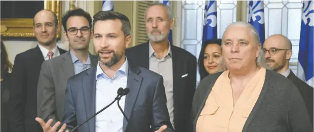  ?? JACQUES BOISSINOT / THE CANADIAN PRESS ?? Québec solidaire co-spokespers­on Gabriel Nadeau-dubois speaks to reporters after a caucus meeting on Nov. 23 as co-spokespers­on Manon Masse,
right, looks on. Quebec MNAS must swear an oath to the King to sit in the National Assembly, but three Parti Québécois MNAS are holding out.