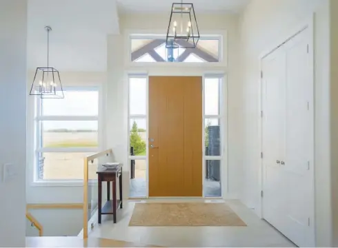  ??  ?? Bright and inviting, the foyer features a fiberglass wood grain front door with sidelight and transom windows adding natural light at entry.