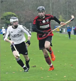  ?? Photograph: Kevin McGlynn. ?? Lovat’s Scott MacKenzie and Oban Camanachd’s Daniel MacCuish in a race for the ball.