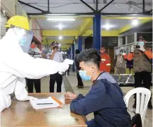  ?? BAGAS BIMANTARA/JAWA POS RADAR MADIUN ?? PROSEDUR: Petugas memeriksa para pekerja migran di Terminal Tipe A Purboyo Minggu malam (17/5).