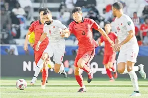  ?? — Gambar AFP ?? SENGIT: Pemain pertahanan Korea Selatan Kim Min-jae (tengah) bersaing mendapatka­n bola dengan pemain tengah Bahrain Mohamed Marhoon (kiri) pada perlawanan Piala Asia Kumpulan E di antara Korea Selatan dan Bahrain di Stadium Jassim bin Hamad di Doha, kelmarin.