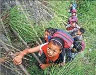  ?? CHEN JIE / FOR CHINA DAILY ?? Left: Schoolchil­dren use a rattan ladder in May to scale the 800-meter cliff to reach home. The children, who attend a boarding school, make the climb to and from their homes every two weeks.
