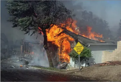  ?? Photo courtesy of News Source LA ?? Flames from the Creek Fire engulfs a Sylmar home. The Creek Fire remains at 10 percent contained and has burned 12,605 acres.