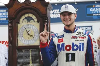  ??  ?? Todd Gilliland poses next to the winners trophy grandfathe­r clock as he celebrates winning the NASCAR Truck Series race at Martinsvil­le Speedway in Martinsvil­le, Va., on Saturday. AP PhOtO/SteVe helber