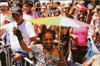  ?? Michael M. Santiago / Getty Images ?? People participat­e in the New York City Pride Parade on Christophe­r Street on Sunday. The parade has been an annual tradition since it was first held in 1970 to observe the one-year anniversar­y of the Stonewall Uprising in Greenwich Village.