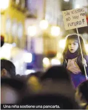  ?? ?? Una niña sostiene una pancarta.