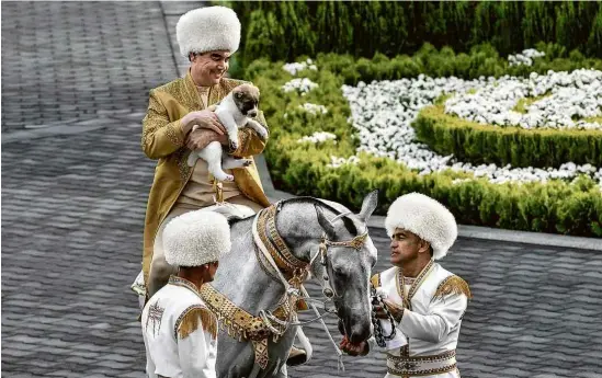  ?? Igor Sasin - 28.abr.18/AFP ?? O ditador Gurbanguly Berdymukha­medov participa de cerimônia durante o Dia do Cavalo, feriado criado por ele, que é obcecado pelo animal