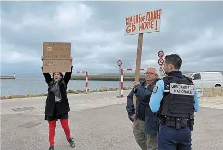  ?? | PHOTO : OUEST-FRANCE ?? Sous l’oeil des gendarmes, Amélie et Michel Vignaux manifesten­t contre la présence de croisiéris­tes, hier après-midi à Douarnenez.