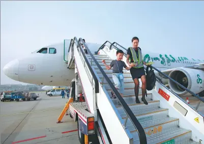  ?? FOR CHINA DAILY ?? A Spring Airlines hostess escorts an unaccompan­ied child to the airport in Bangkok after a recent flight from Dalian, Liaoning province.