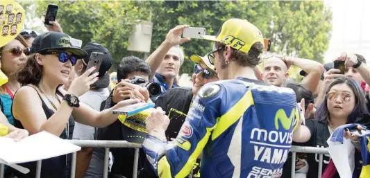  ??  ?? Valentino Rossi, 36 anni, anche a Sepang assediato dai fan per un autografo o un selfie. Alcuni di loro indossavan­o anche delle t-shirt “storiche” del pilota marchigian­o