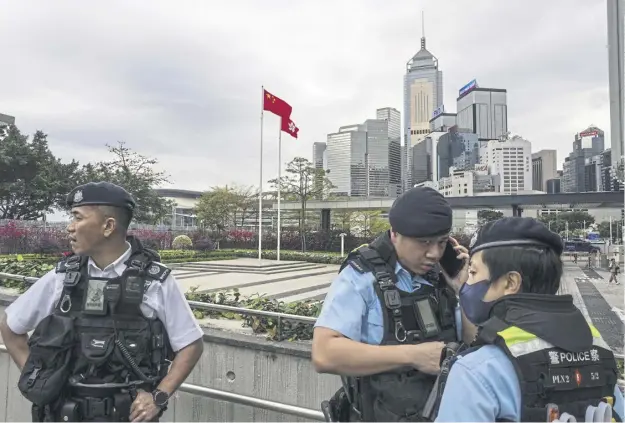  ?? ?? Police officers stand guard outside the Legislativ­e Council in Hong Kong yesterday as the proposed national security law granting the government more power to quash dissent was passed
