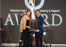  ?? ?? Hee presents an award to brand ambassador and supermodel Amber Chia during the MFMPA ceremony.