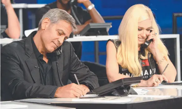  ?? Picture: GETTY IMAGES ?? Hollywood actor George Clooney and pop star Gwen Stefani answer phones in Los Angeles during the Hand in Hand telethon.