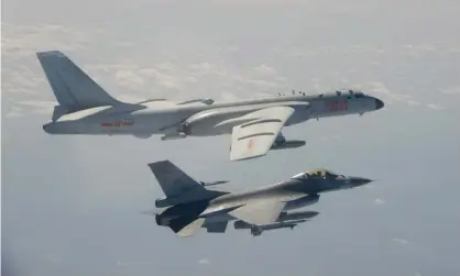  ?? Photograph: HANDOUT/Taiwan's Defence Ministry/AFP via Getty Images ?? A Taiwanese F-16 fighter jet flies next to a Chinese H-6 bomber (top) in Taiwan airspace. China has sanctioned major US defence companies for selling weapons to Taipei.