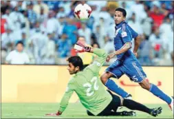  ??  ?? مهاجم الهلال ناصر الشمراني يضع الكرة من فوق حارس الأهلي عبدالله معيوف