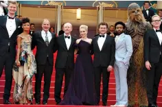  ?? Photo by Joel C Ryan/Invision/AP ?? ■ Actors Joonas Suotamo, from left, Thandie Newton, Woody Harrelson, director Ron Howard, actors Emilia Clarke, Alden Ehrenreich, Donald Glover, a person dressed as the character Chewbacca and actor Paul Bettany pose for photograph­ers Tuesday upon...