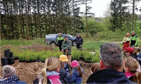  ?? SEBASTIAN GRIMM (4) ?? Elger Kohlstedt, Leiter des Forstamtes Leinefelde (Mitte), erklärt den Teilnehmer­n, wie die Setzlinge gepflanzt werden müssen. Auch erfahren die Mädchen und Jungen ganz nebenbei vieles über den Wald.