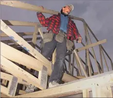  ?? Calgary Herald Archive ?? A constructi­on worker helps build a house within Copperfiel­d in 2002. The community’s progress from fields to homes fascinated Harley Hotchkiss.