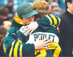  ?? CP PHOTO ?? Mourners comfort each other during a vigil at the Elgar Petersen Arena, home of the Humboldt Broncos, to honour the victims of a fatal bus accident in Humboldt, Sask. on Sunday.