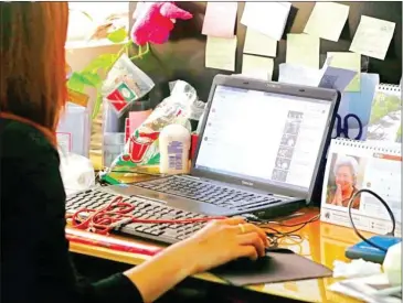  ?? HENG CHIVOAN ?? A woman looks at videos posted to a social media website in Phnom Penh on Monday.