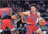  ?? CARLOS OSORIO/AP ?? Pistons guard Cade Cunningham drives around Nets guard DeAndre’ Bembry on Dec. 12 in Detroit. Cunningham is averaging 15.4 points, 6.2 rebounds and 5.3 assists this season.