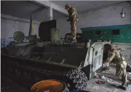  ?? ?? ARMAS.
Militares ucranianos, al inspeccion­ar un tanque ruso en Kharkiv, ayer.