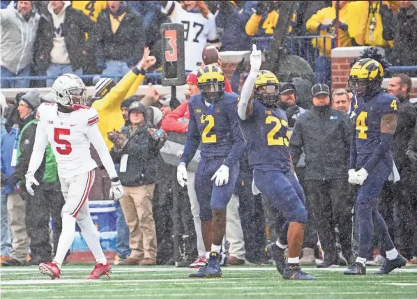  ?? PHOTOS BY ADAM CAIRNS/COLUMBUS DISPATCH ?? Vincent Gray (4), Michael Barrett (23) and Brad Hawkins (2) celebrate breaking up a pass intended for OSU’S Garrett Wilson.