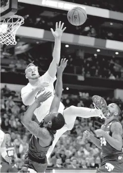  ?? AP Photo/Bob Leverone ?? ■ Kansas State’s Barry Brown, front, tries to shoot over Creighton’s Toby Hegner, top, during the second half of a first-round game in the NCAA basketball tournament Friday in Charlotte, N.C.