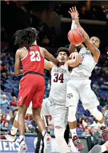  ?? AP Photo/Jeff Roberson ?? ■ Texas A&M’s Tyler Davis (34) collides with teammate T.J. Starks (2) while reaching for a rebound as Alabama’s John Petty (23) watches during the first half at the Southeaste­rn Conference tournament Thursday in St. Louis.